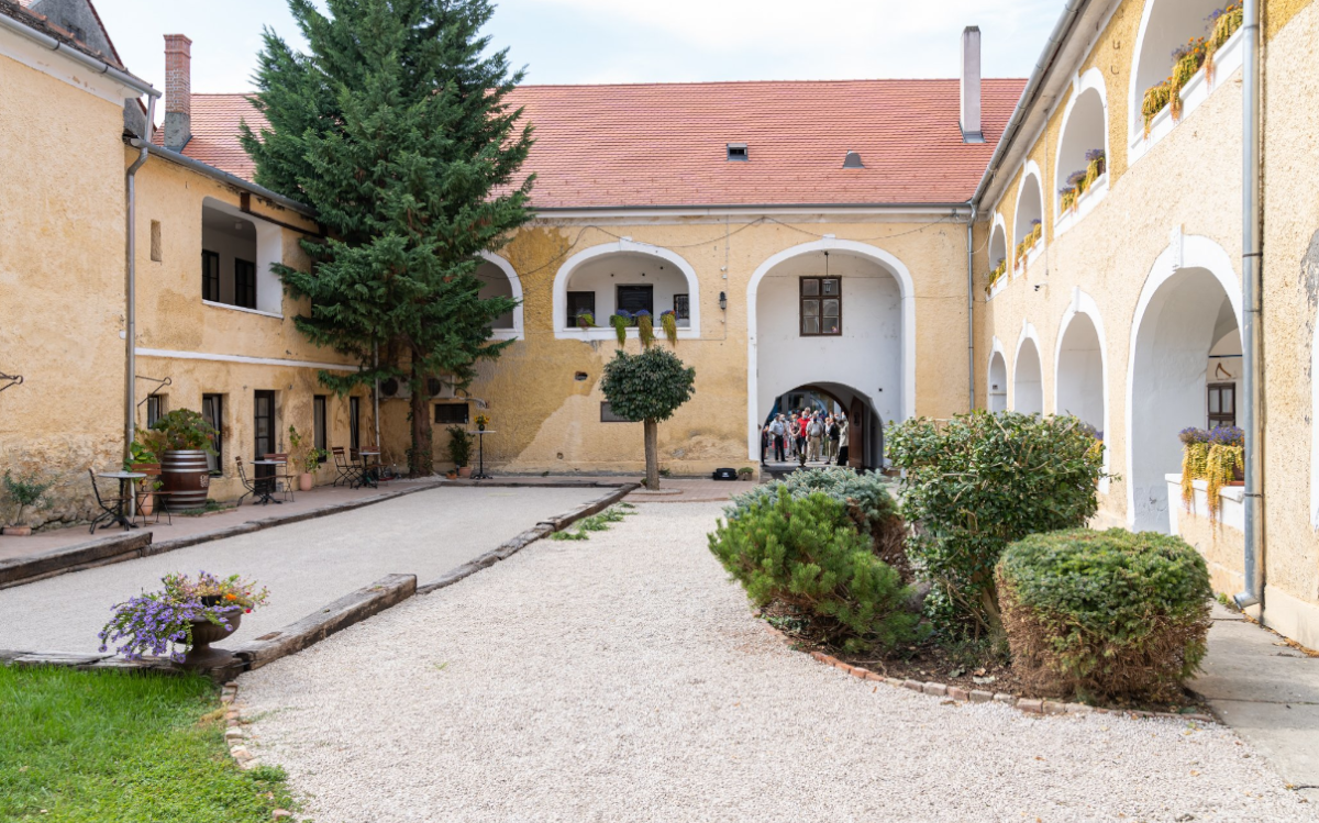 Der Innenhof des Pethő-Hauses mit dem Petanque-Platz und dem Gebäude der Synagoge